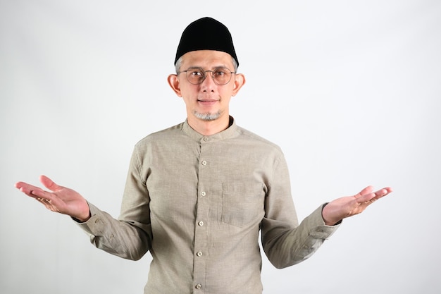 Portrait d'un homme asiatique musulman souriant les bras ouverts lors de la pose de voeux