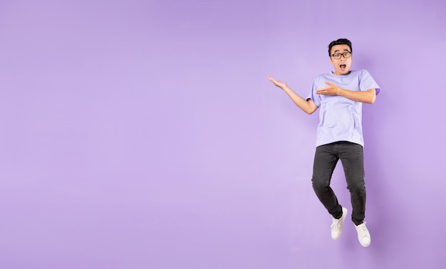 Portrait d'un homme asiatique sautant, isolé sur fond violet