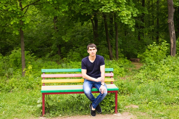 Portrait d'un homme assis sur un banc dans un parc