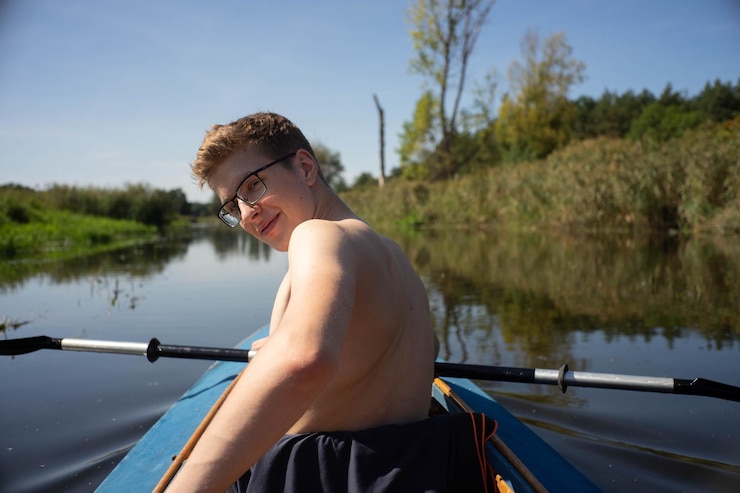 Photo portrait d'un homme assis sur un bateau dans un lac