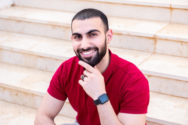 Portrait d'un homme assis dans les escaliers en souriant