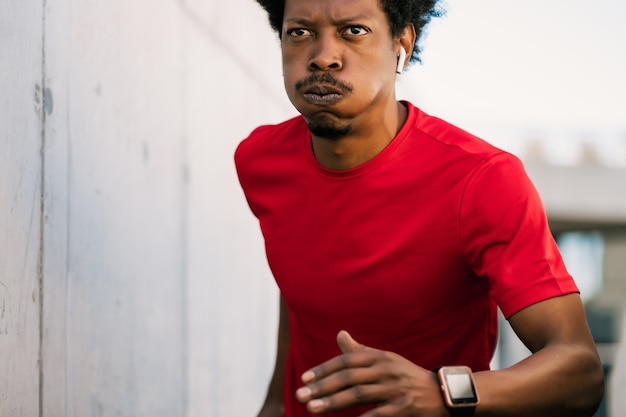 Portrait d'homme athlète afro en cours d'exécution et faire de l'exercice à l'extérieur. Sport et mode de vie sain.