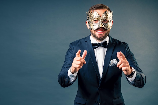 Portrait d'homme au masque de carnaval sur fond gris homogène Visage sous masque