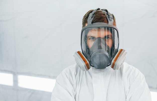 Portrait d'homme au masque de protection Travailleur en uniforme est au service automobile