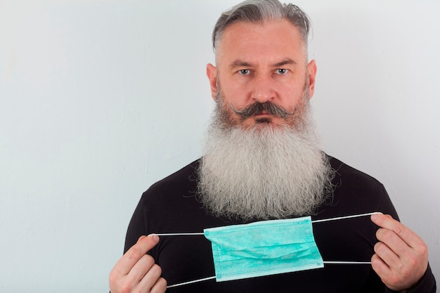 Portrait d'un homme barbu d'âge moyen dans un masque médical.