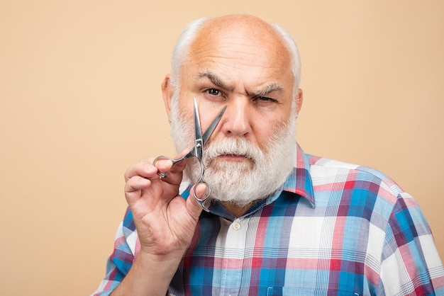 Portrait d'homme barbu élégant avec barbe moustache grise tenir des ciseaux de coiffeur près du visage