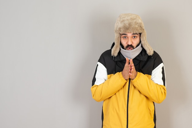 Portrait d'homme barbu gelé dans des vêtements chauds debout et posant.