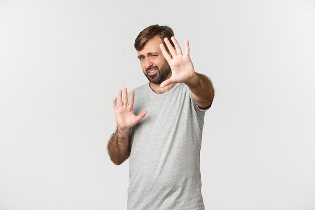 Portrait d'homme barbu mécontent en t-shirt gris