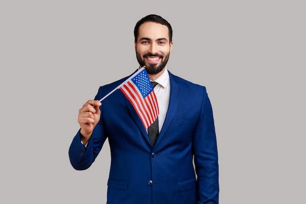 Portrait d'un homme barbu optimiste positif tenant le patriotisme du drapeau des états-unis d'amérique