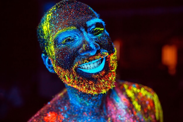 Portrait d&#39;un homme barbu peint en poudre fluorescente.