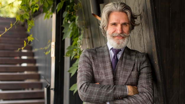 Portrait d'homme barbu posant à l'extérieur