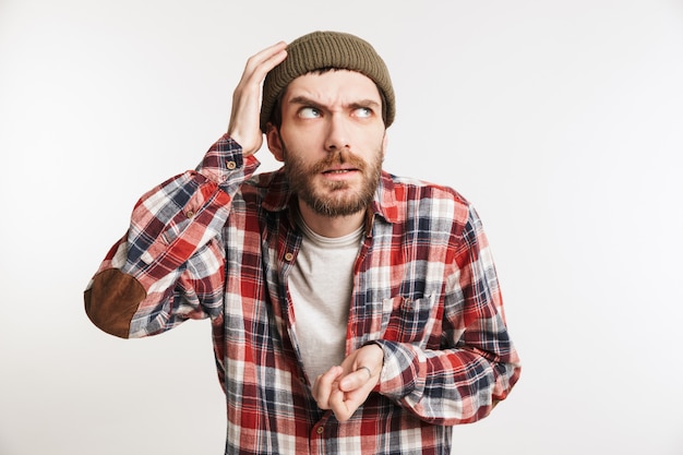 Portrait d'un homme barbu réfléchi en chemise à carreaux