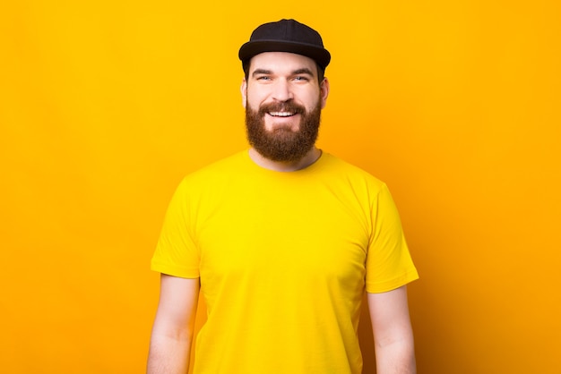 Portrait d'homme barbu souriant sur jaune