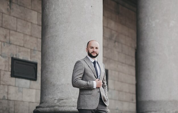 Portrait d'un homme beau à la mode grave en costume posant dans la ville