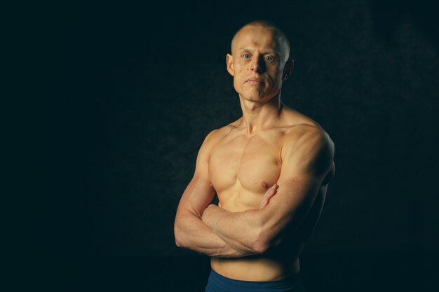 Portrait d'un homme beau et musclé en fond sombre. Tonifié