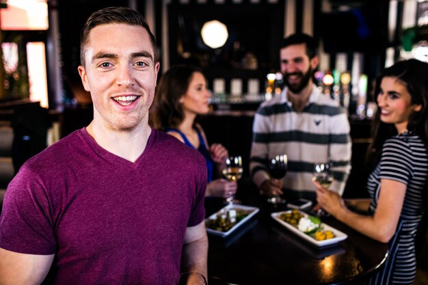 Portrait d&#39;un homme buvant un verre avec des amis dans un bar