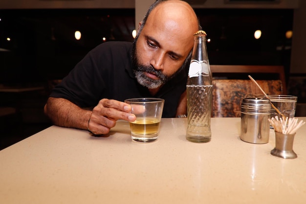 Photo portrait d'un homme buvant un verre sur la table