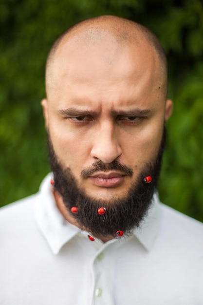 Portrait d'homme en colère drôle avec décoration dans sa barbe