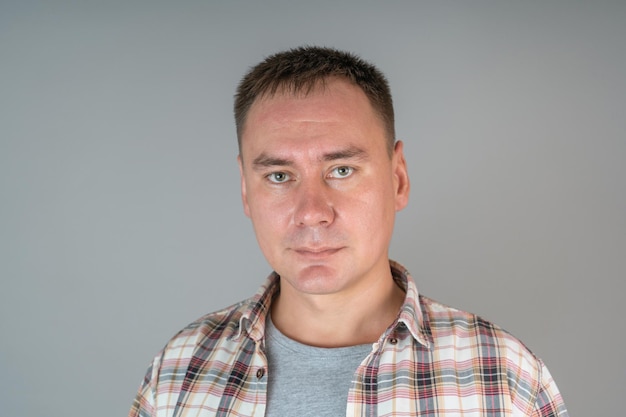 Portrait d'un homme confiant dans une chemise âgée de 30 ans, sur fond gris