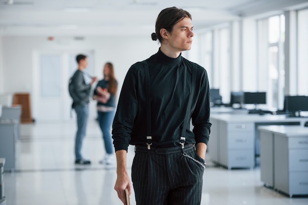 Portrait d'homme confiant. Groupe de jeunes marchant dans le bureau à leur pause