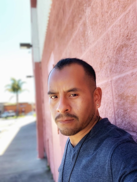 Photo portrait d'un homme contre un mur en ville