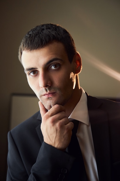 Portrait d'un homme en costume-cravate près de la fenêtre