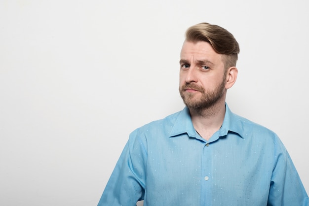 Portrait d'un homme avec une coupe de cheveux élégante dans une chemise bleue