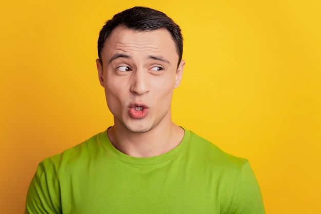 Portrait d'un homme curieux et excité regarde l'espace vide bouche ouverte sur fond jaune