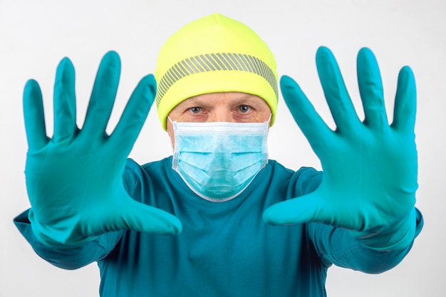 Portrait d'un homme dans un masque médical avec les mains levées dans des gants de protection. mains propres et mise en quarantaine