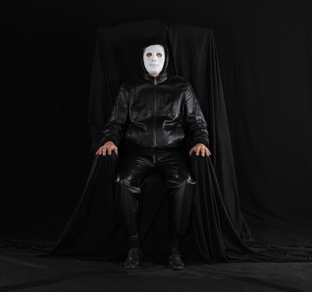 portrait d'un homme dans un masque théâtral étrange sur un fond noir