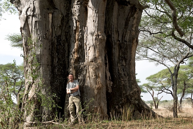 Portrait d'un homme debout devant un baobab, Tanzanie, Afrique