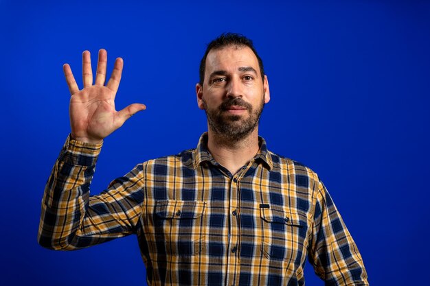 Portrait d'un homme debout sur un fond bleu