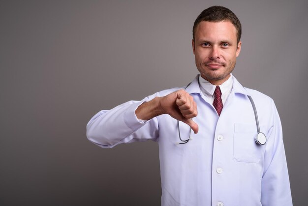 Photo portrait d'un homme debout sur un fond gris