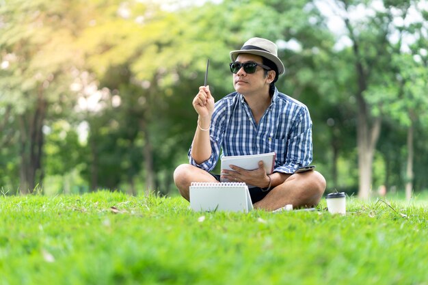 Portrait, de, a, homme décontracté, dans, chapeau, tenue, cahier, et, penser, dans, vert, parc