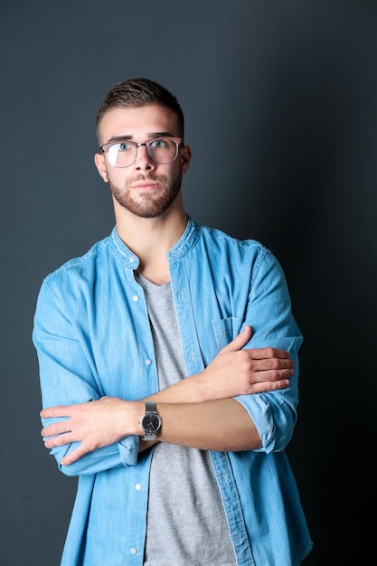 Portrait d'un homme décontracté heureux debout isolé sur un fond sombre beau mâle posant