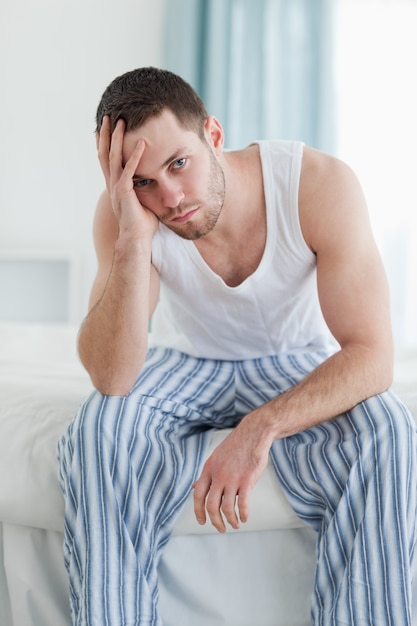 Portrait d'un homme déprimé assis sur son lit