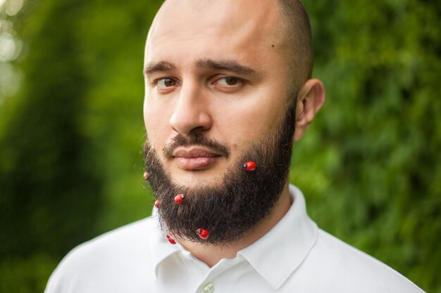 Portrait d'homme drôle avec décoration dans sa barbe