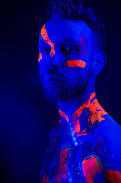 Portrait d'un homme avec du maquillage ultraviolet et de la lumière au néon dans un style cyberpunk