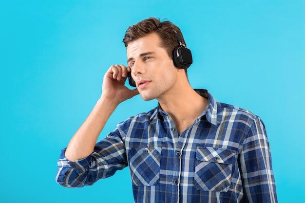 Portrait d'un homme écoutant de la musique sur des écouteurs sans fil s'amusant sur bleu