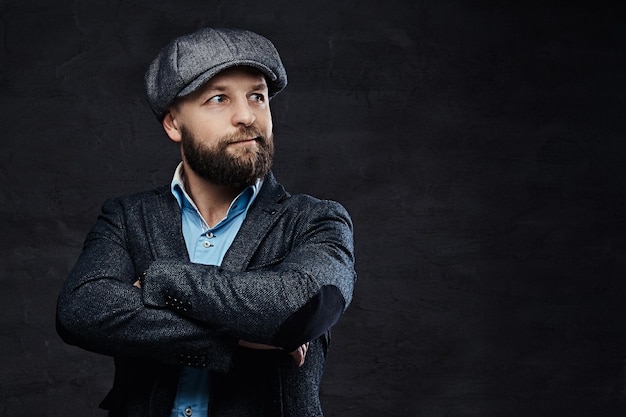 Portrait d'un homme élégant à l'ancienne portant un béret et une veste avec les bras croisés