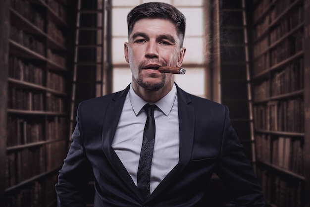 Portrait d'un homme élégant en costume avec un cigare. Concept d'entreprise. Technique mixte