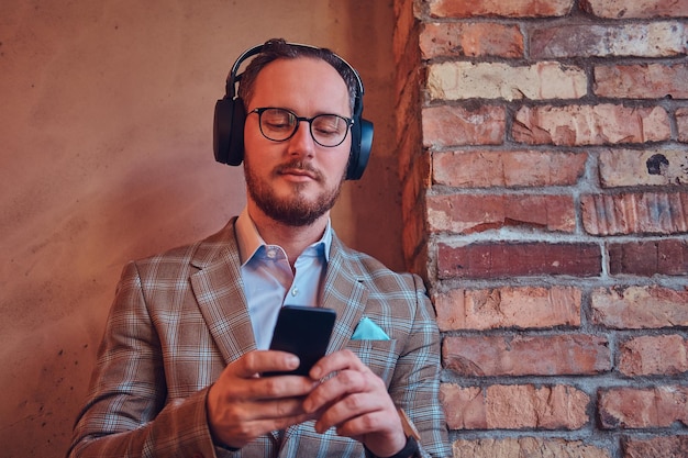 Portrait d'un homme élégant dans un costume de flanelle et des lunettes à l'écoute