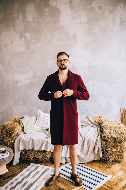 Portrait d'un homme élégant dans un pardessus, à l'intérieur