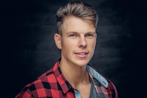 Portrait d'un homme élégant positif dans une chemise rouge sur fond gris.