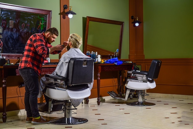 Portrait d'un homme élégant se rasant la barbe Un coiffeur dans un barbier Un homme dans un salon de coiffure avec une coupe de cheveux hipster Une barbe et des moustaches Un coiffureur professionnel dans un barberie