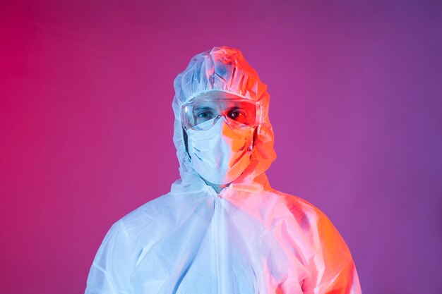 Portrait d'homme avec un équipement de protection chimique pour covid-19 sur fond coloré