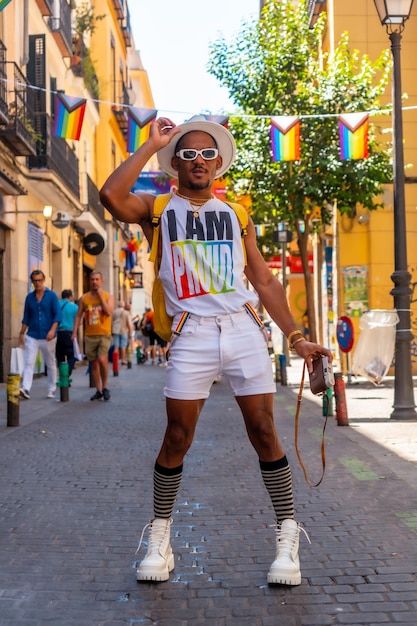 Portrait d'un homme ethnique noir gay à la fête de la fierté prenant des photos avec un chapeau drapeau LGBT