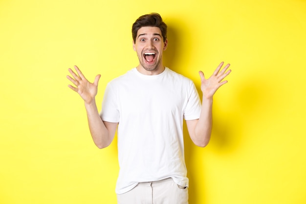 Portrait d'un homme excité et surpris réagissant à une grande offre promotionnelle criant de joie et triomphant de st...