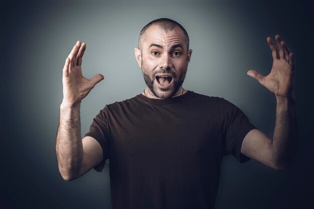 Photo portrait d'un homme faisant des gestes sur un fond gris