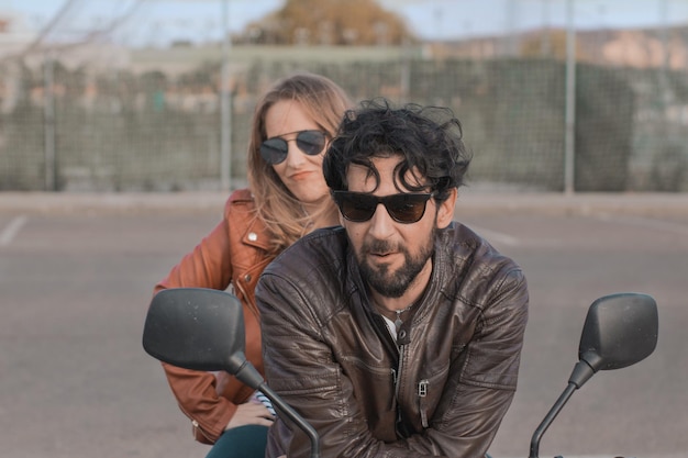 Portrait d'un homme et d'une femme assis sur une moto en ville